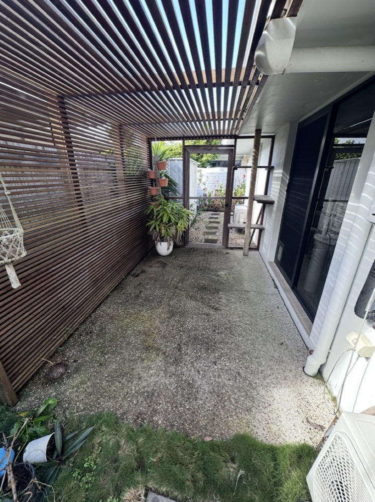 A pergola patio floor stained and mossy before pressure washing