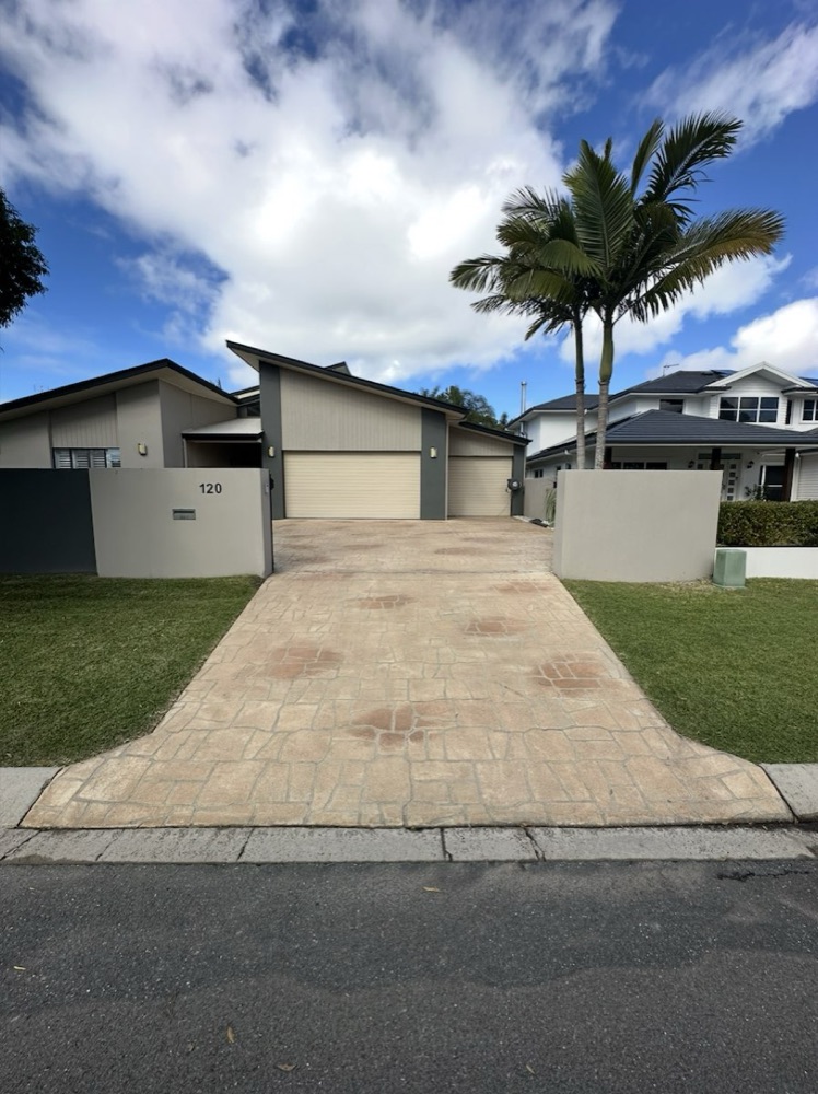 A clean stamped concrete driveway leading up to a home's garage