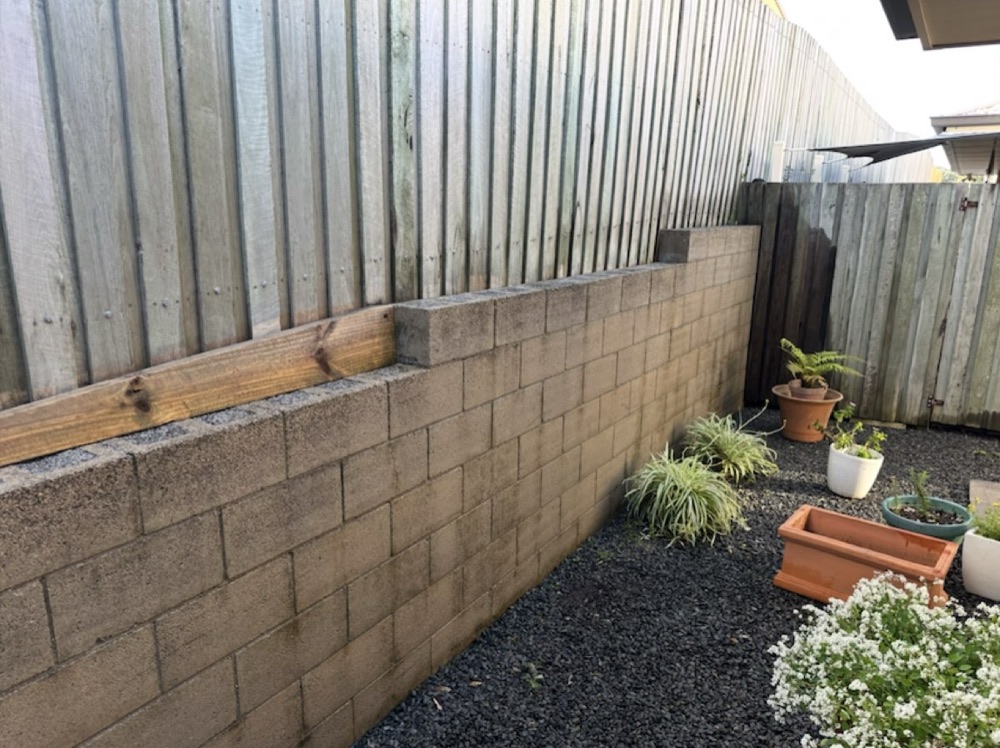The same retaining wall back to its original colour after pressure washing