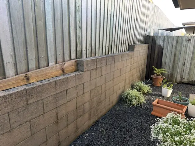 A block retaining wall back to its original colour after pressure washing